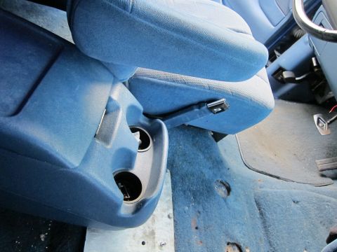 2001 Ford Crown Victoria - Interior view of a car, showing blue seats and a center console with cup holders.