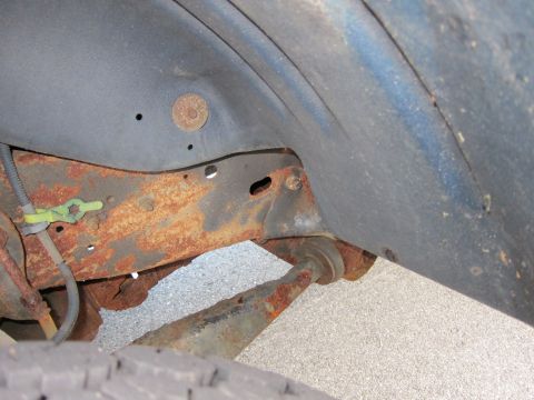 2001 Ford Crown Victoria - Close-up view of heavily rusted undercarriage components, indicating potential structural compromise.