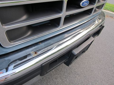 2001 Ford Crown Victoria - Close-up of a Ford truck's front grille and bumper, showing the Ford emblem and a license plate bracket.