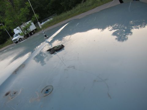 2001 Ford Crown Victoria - Car hood detail with antenna and debris, white truck in background.