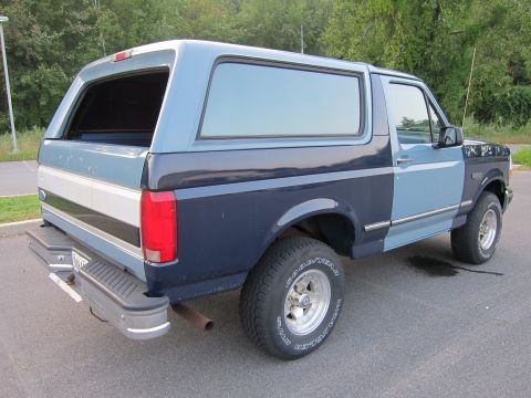 2001 Ford Crown Victoria - This Ford Bronco has a two-tone blue paint job and a camper shell, seen from the rear.