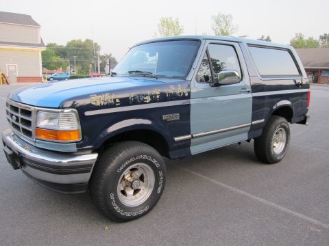 2001 Ford Crown Victoria - This two-tone Ford Bronco features a distinctive blue and gray paint scheme with visible wear on the hood.