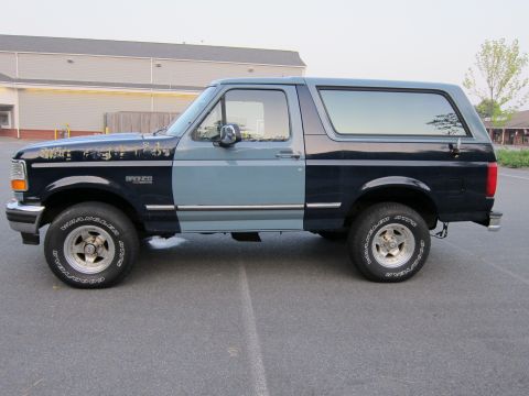 2001 Ford Crown Victoria - Side view of a two-tone Ford Bronco with visible wear on the hood.