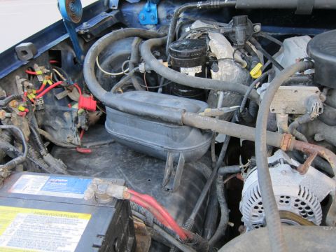 2001 Ford Crown Victoria - Close-up view of a vehicle's engine bay, highlighting the battery and alternator components.