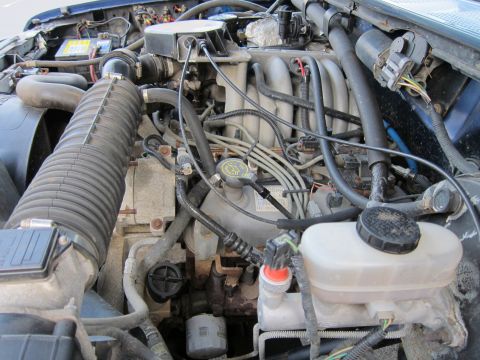 2001 Ford Crown Victoria - Close-up view of a vehicle's engine bay, showing various mechanical parts and wiring.