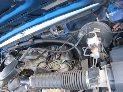 2001 Ford Crown Victoria - Engine bay of a blue vehicle, showing various mechanical parts and wiring under the open hood.