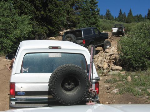 1995 Ford Bronco - A convoy of SUVs navigates a rocky trail in the mountains.
