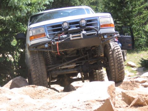 1995 Ford Bronco - This 1995 Ford Bronco navigates a challenging rocky trail, its off-road capabilities with a custom bumper and winch.