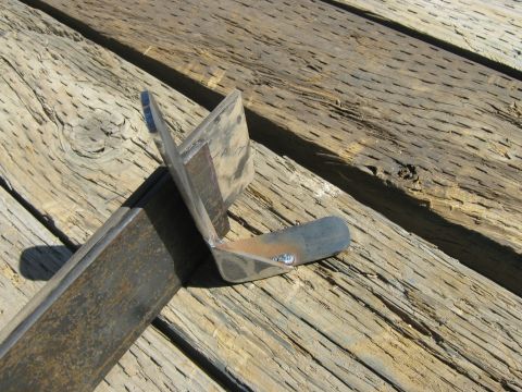 1972 Ford F-250 - Custom metal bracket, likely for a vehicle repair or modification, shown on weathered wood.