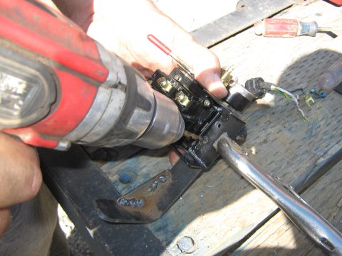 1972 Ford F-250 - A drill is used on a black electrical component with wires, attached to a metal bracket.