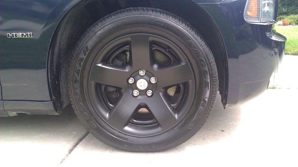 Matte black five-spoke wheel with Goodyear Eagle tire on a black Dodge with HEMI badge