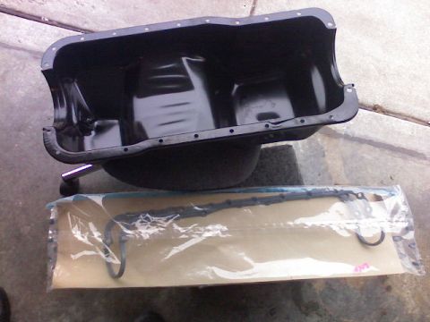 1987 Mercury Grand Marquis - A black oil pan and a gasket set are shown, likely for an automotive repair.