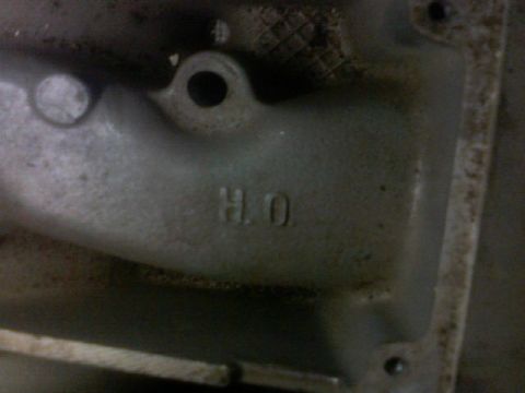 1987 Mercury Grand Marquis - Close-up of a metal engine component with the marking "H.O."