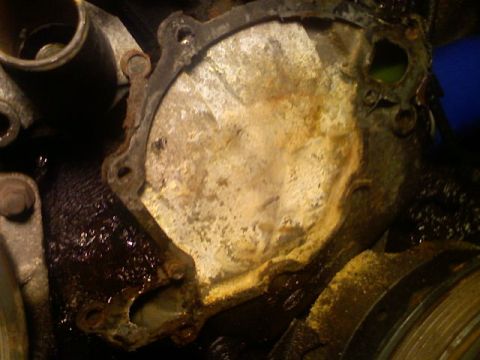 1987 Mercury Grand Marquis - This is a close-up view of a corroded engine water pump gasket, showing signs of wear and oil residue.