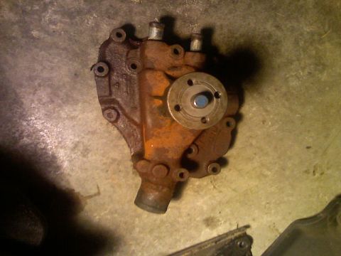 1987 Mercury Grand Marquis - A rusty metal automotive part is shown from above, resting on a concrete surface.