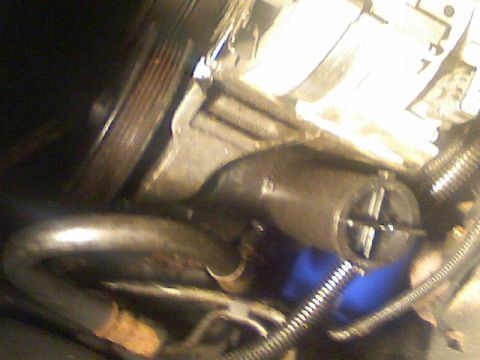 1987 Mercury Grand Marquis - A close-up view of engine components, a pulley and various hoses, with a watermark at the bottom right.