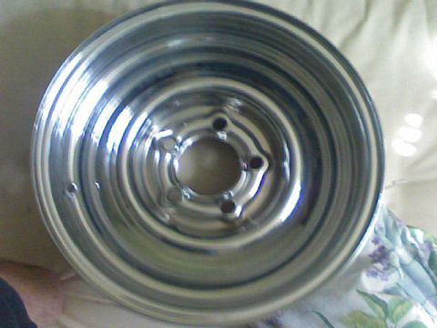 1987 Mercury Grand Marquis - A single chrome wheel is shown up close, with a patterned cloth visible in the background.