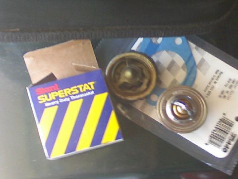 1987 Mercury Grand Marquis - Two thermostats and a gasket are shown next to a Stant Superstat box.