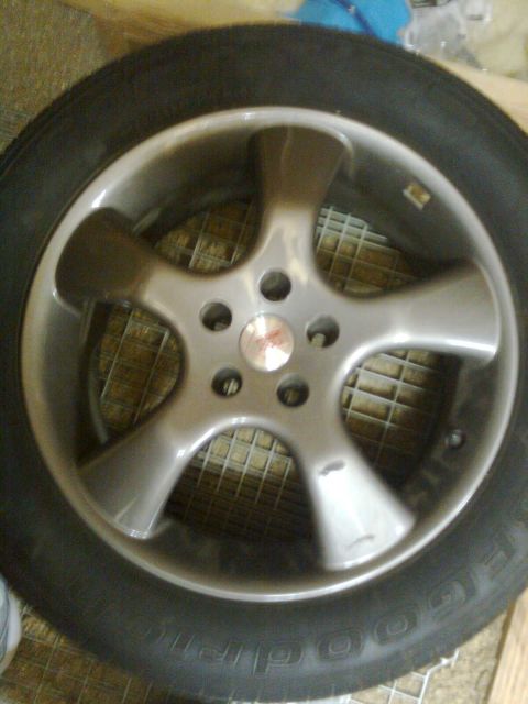 1984 Ford Bronco - Close-up of a silver 5-spoke alloy wheel and tire. The Supermotors.net logo is visible on the tire.