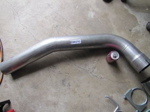 1995 Ford Bronco - An exhaust pipe is shown with a part number sticker and a soda can for scale.