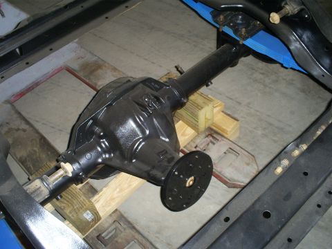 1992 Ford Bronco - A black rear axle differential assembly is shown, mounted within a vehicle's frame and connected to leaf springs.