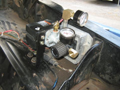 1972 Ford F-250 - Close-up of an air compressor and pressure gauges installed in a vehicle's engine compartment.