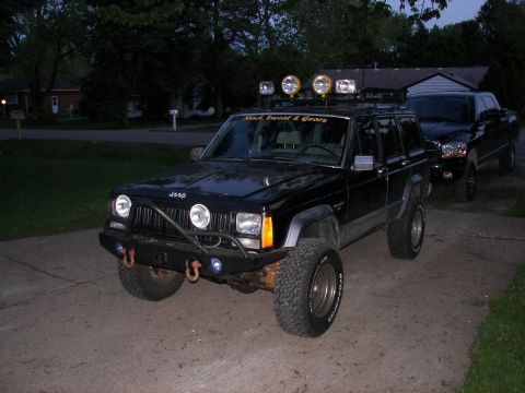 1988 Ford Bronco - A black Jeep Cherokee XJ is parked in a driveway, with another vehicle behind it.
