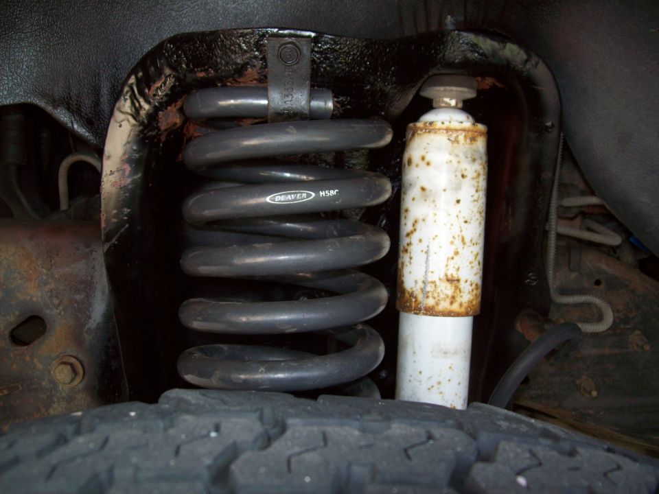 Front suspension coil with 'DEAVER H50R' text and rusty shock absorber