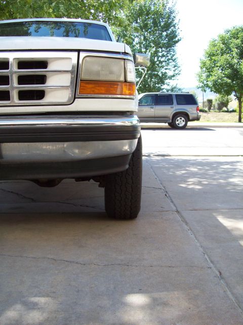 1993 Ford F-150 - A close-up view of the front of a white pickup truck, with another vehicle parked behind it.