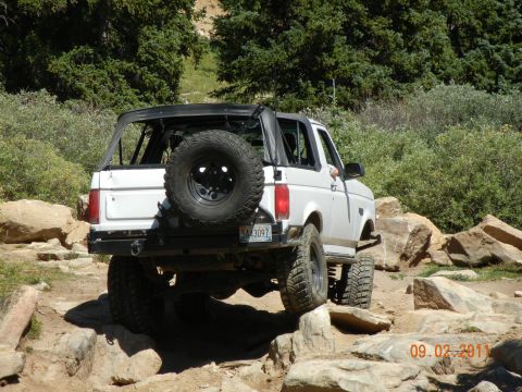 1996 Ford Bronco - 1996 Ford Bronco navigating a challenging rocky trail with its top down.