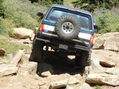 1996 Ford Bronco - Ford Bronco tackling a challenging off-road course on a sunny day.
