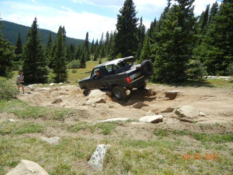 1996 Ford Bronco - A Ford Bronco tackles a challenging off-road course in a wooded, mountainous area.