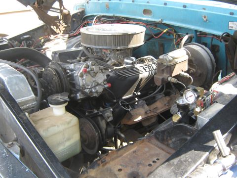 1972 Ford F-250 - The engine bay of a light blue truck, a V8 engine with an aftermarket air cleaner and chrome valve covers.