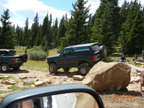1996 Ford Bronco - A 1996 Ford Bronco navigates a rocky off-road course, with another Bronco visible in the background.