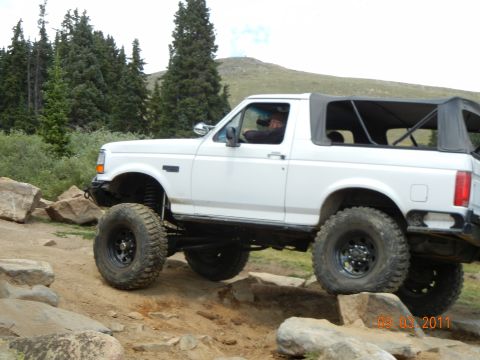 1996 Ford Bronco - White 1996 Ford Bronco navigating a rocky off-road trail.