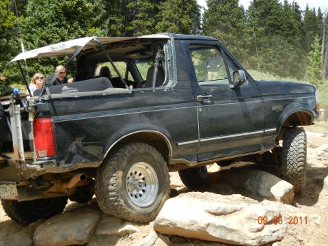 1996 Ford Bronco - 1996 Ford Bronco navigating a rocky trail with passengers inside.