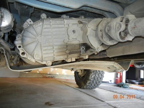 1996 Ford Bronco - Close-up of the transfer case and driveshaft assembly on a vehicle's underside.