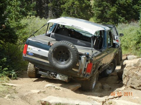 1996 Ford Bronco - This 1996 Ford Bronco navigates a challenging rocky trail with its white soft top deployed.