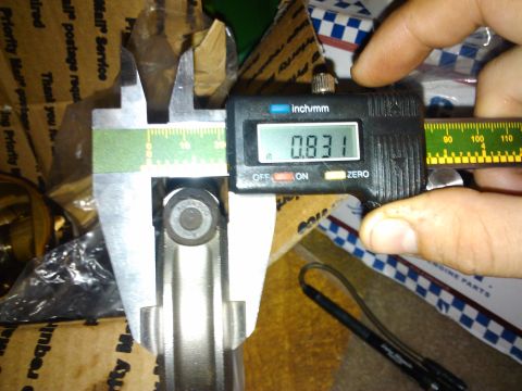 1995 Ford Probe - Measuring a metal part with digital calipers, showing a reading of 0.831 inches.