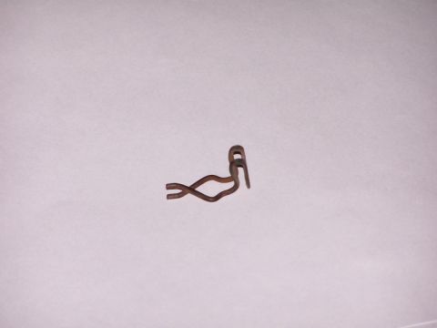 1973 Ford Bronco - small rusty bent wire spring retaining clip photographed on a plain white sheet.