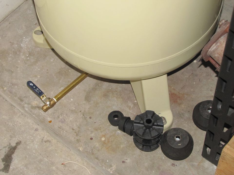 Air compressor tank drain valve and rubber mounts on concrete floor