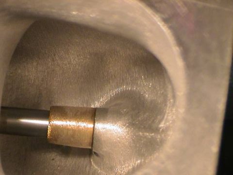 1979 Ford Bronco - A close-up view of an engine's cylinder head, showing a valve stem with a brass bushing.