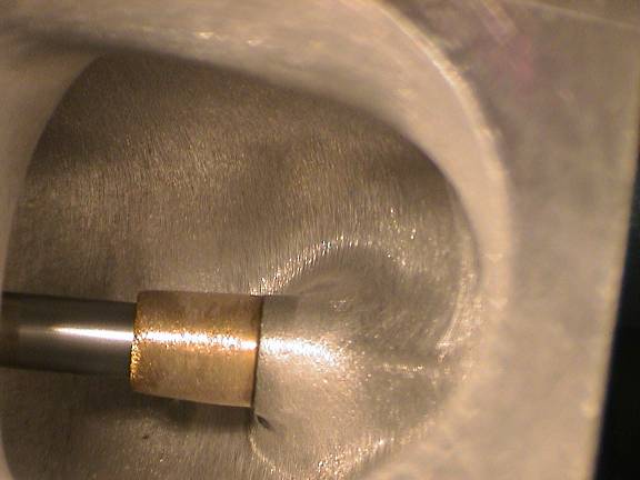 Die grinder carbide burr cutting inside an aluminum cylinder head port bowl