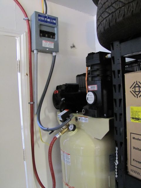 1993 Ford F-250 - An air compressor unit is shown next to an electrical panel and a spare tire on a shelf.
