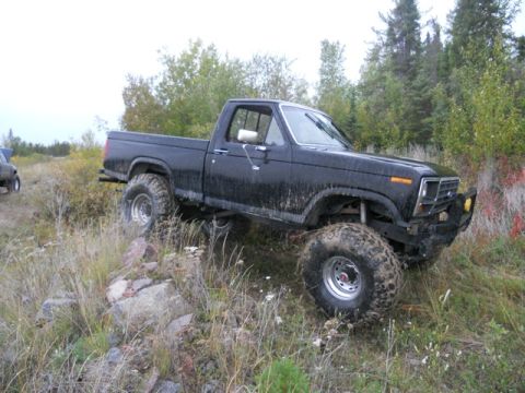 1986 Ford F-150 - This lifted 1980s Ford F-150 pickup truck navigates a rocky, off-road trail.