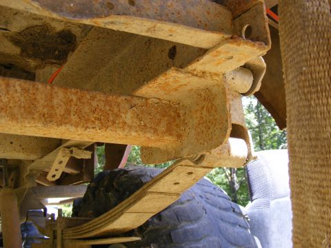 1978 Ford Bronco - Underside view of a heavily rusted vehicle frame and suspension components.