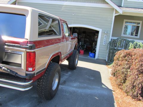 1984 Ford Bronco - This two-tone Ford Bronco is parked in front of a garage.