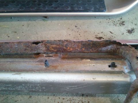 1996 Ford Bronco - The rocker panel of a vehicle shows extensive rust damage, indicating a need for repair.