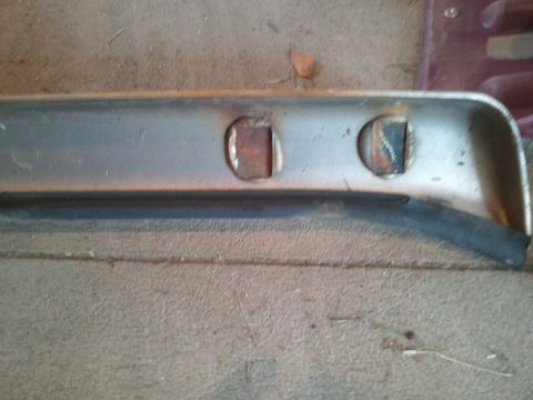 1996 Ford Bronco - This is a close-up view of a metal component with two holes and a rubber trim.