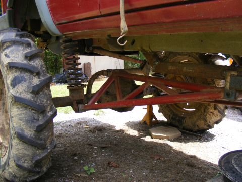 1978 Ford Bronco - The underside of a heavily modified vehicle shows large tires and custom suspension parts.